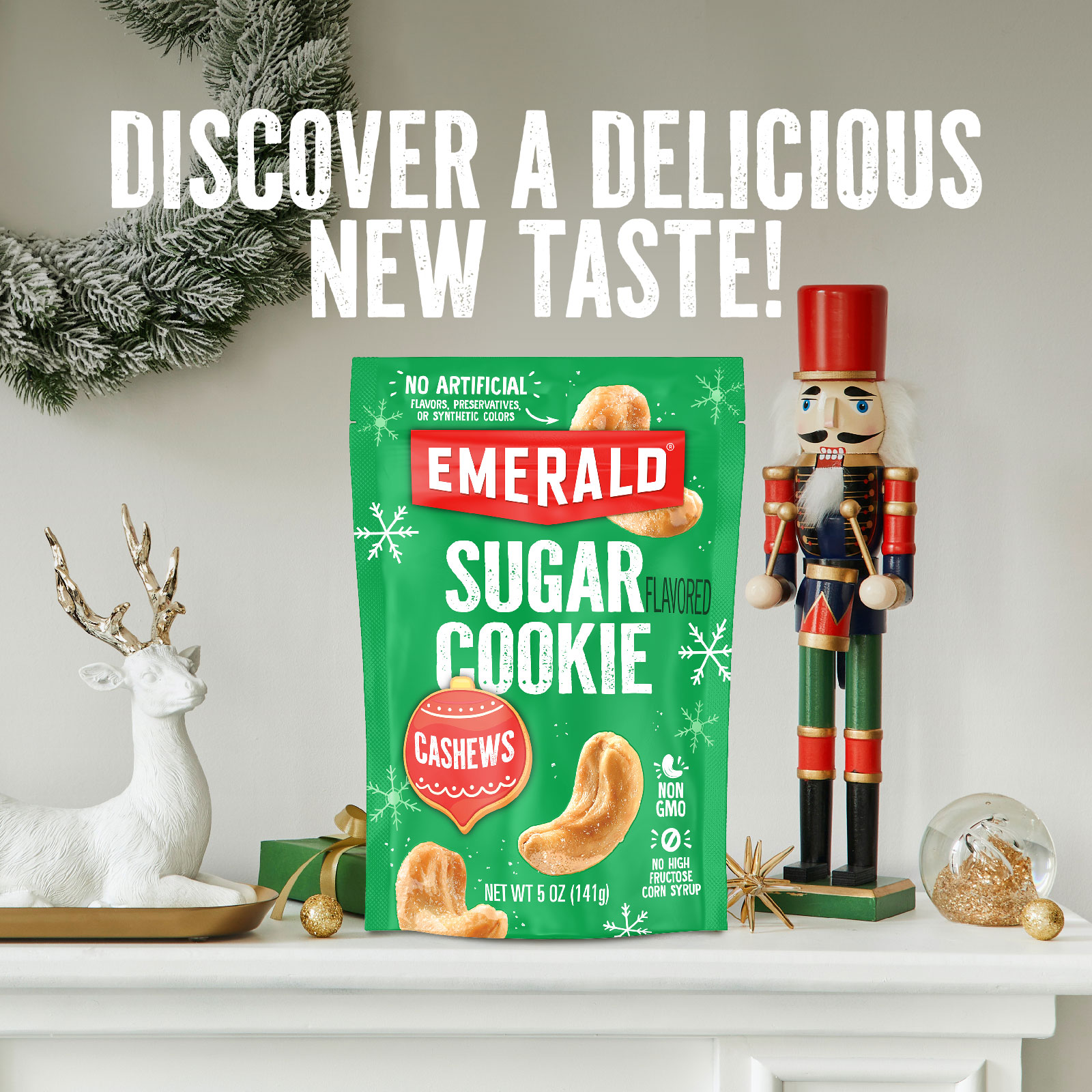 A festive mantle display featuring a bag of Emerald Sugar Cookie flavored cashews. The mantle is decorated with a white reindeer, a nutcracker, a small evergreen wreath, and a clear glass ornament. Bold text above reads, Discover a Delicious New Taste!.